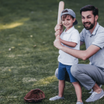 dad teaching son how to play baseball